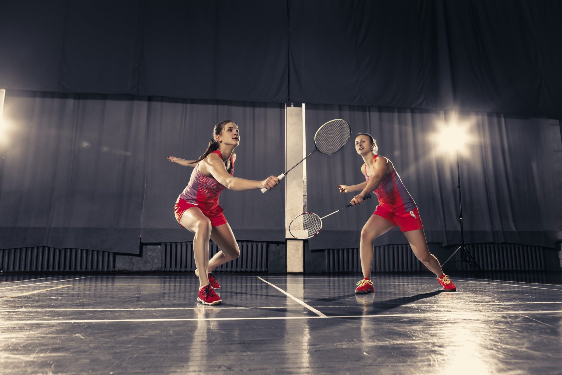 young-women-playing-badminton-at-gym-e1657172609286.jpg